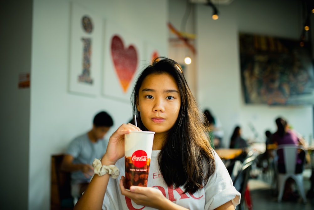woman holding Coca-Cola soda cup