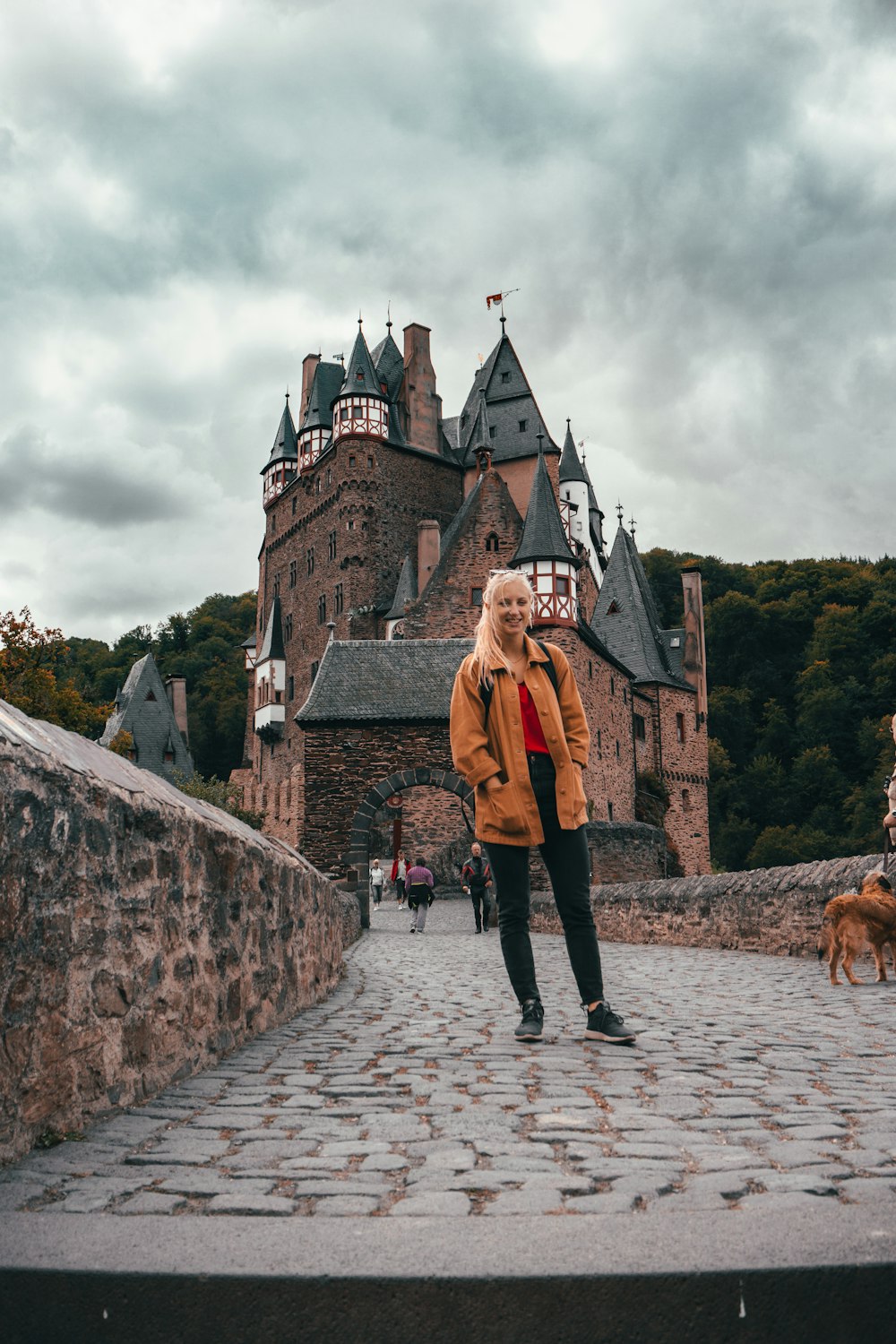 woman wearing jacket standing near castle during daytime