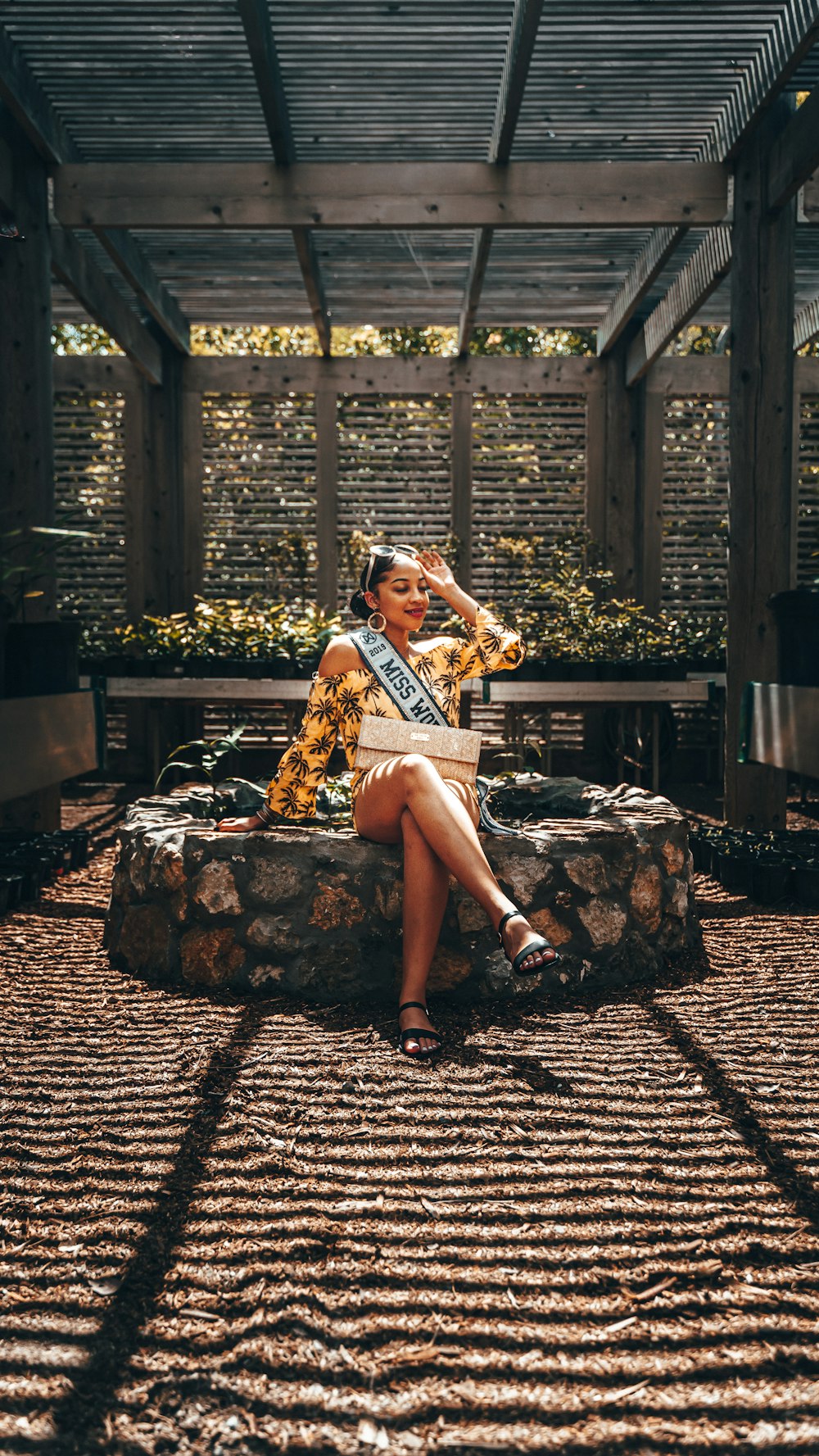 a woman sitting on a stone bench wearing a crown