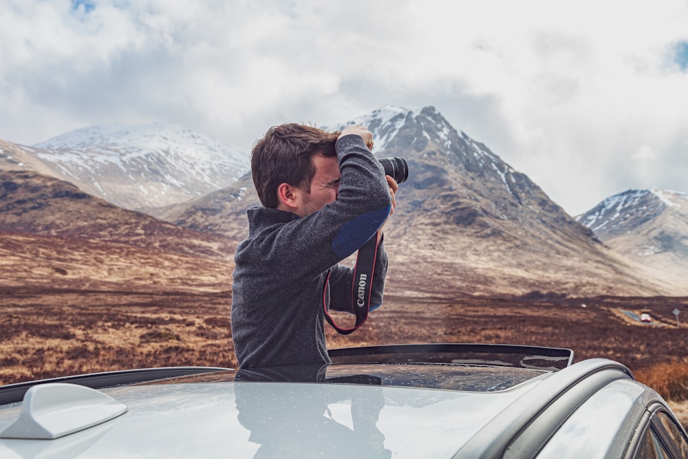 man using camera inside car during day