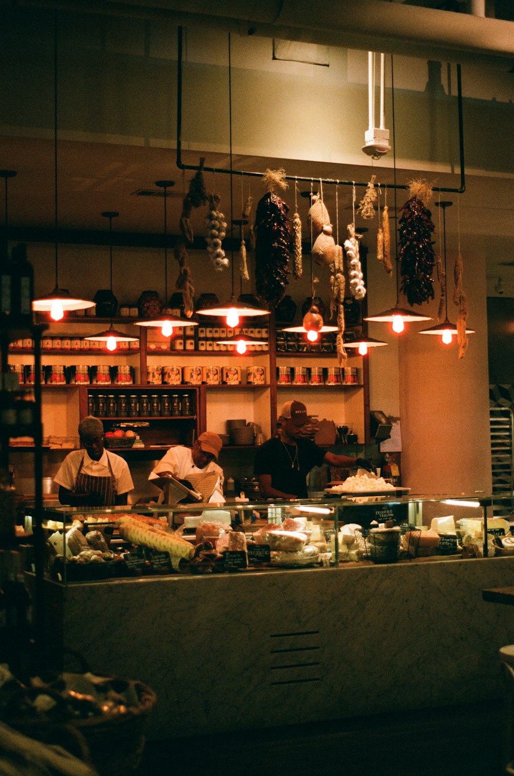 three men standing in front of displayed food