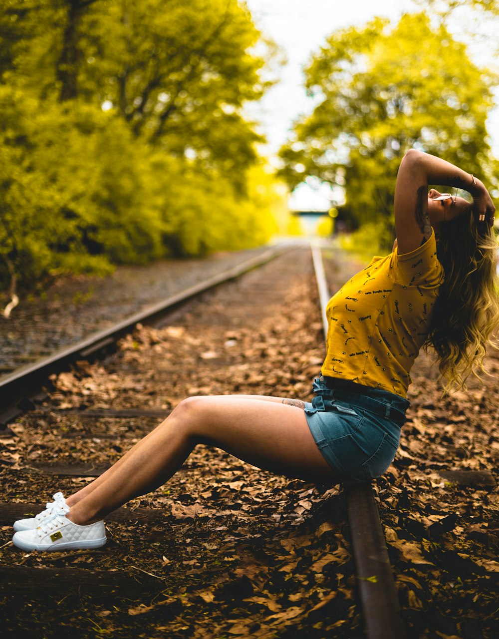 woman sitting on railroad in macro photography