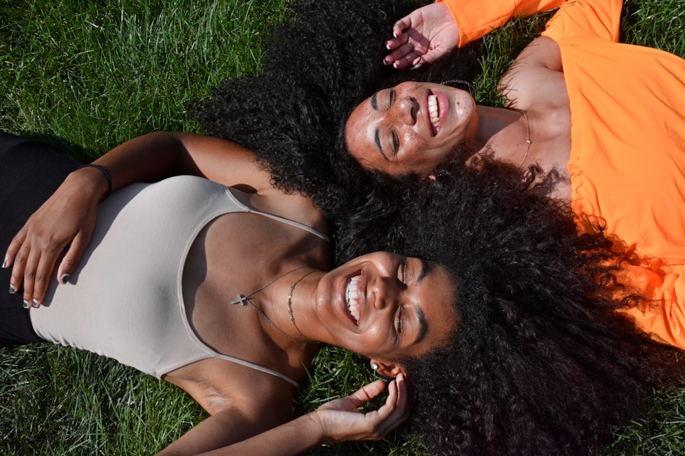 duas mulheres deitadas na grama verde