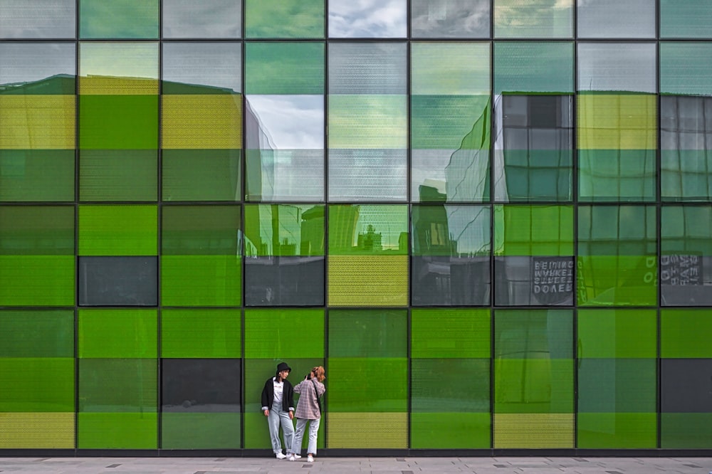 women leaning on glass wall