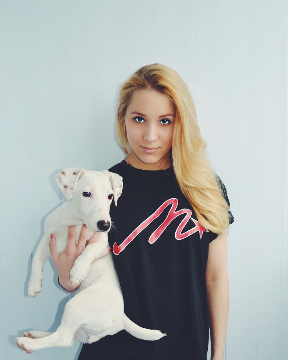 woman holding white puppy