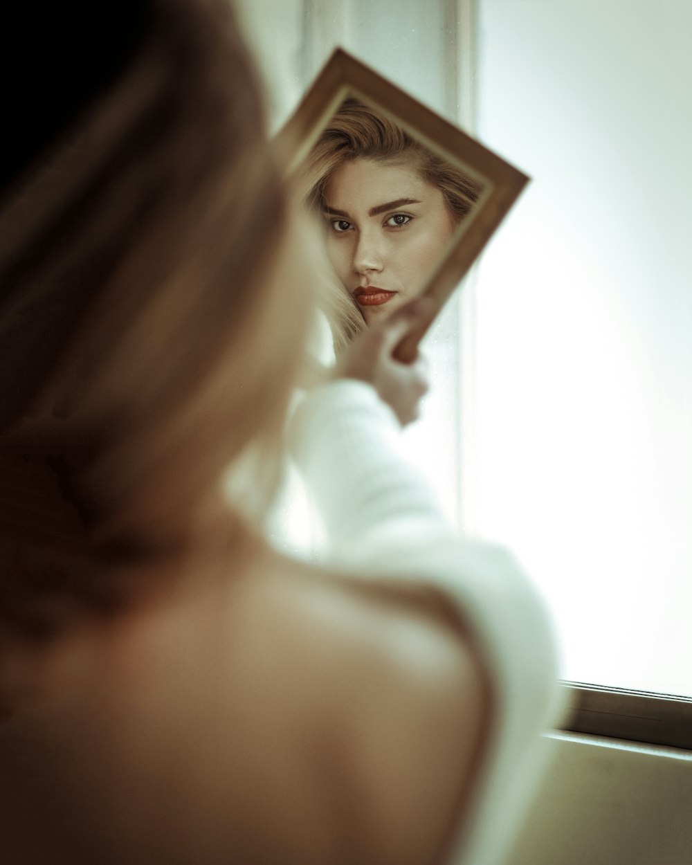 a woman looking at herself in a mirror