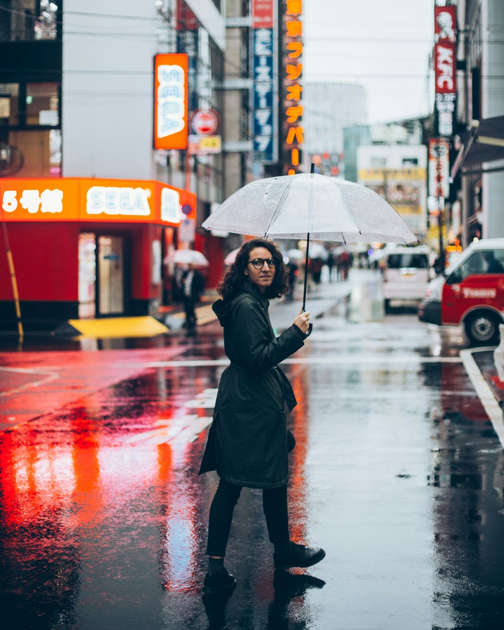 woman holding umbrella walking in street