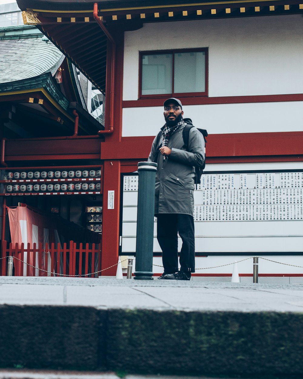 man in gray jacket and black pants standing outdoors