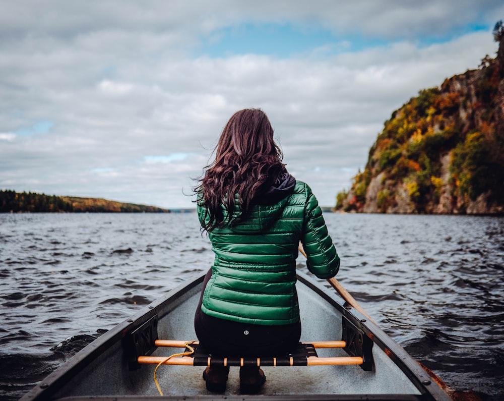 Mujer sentada en el barco en el lago