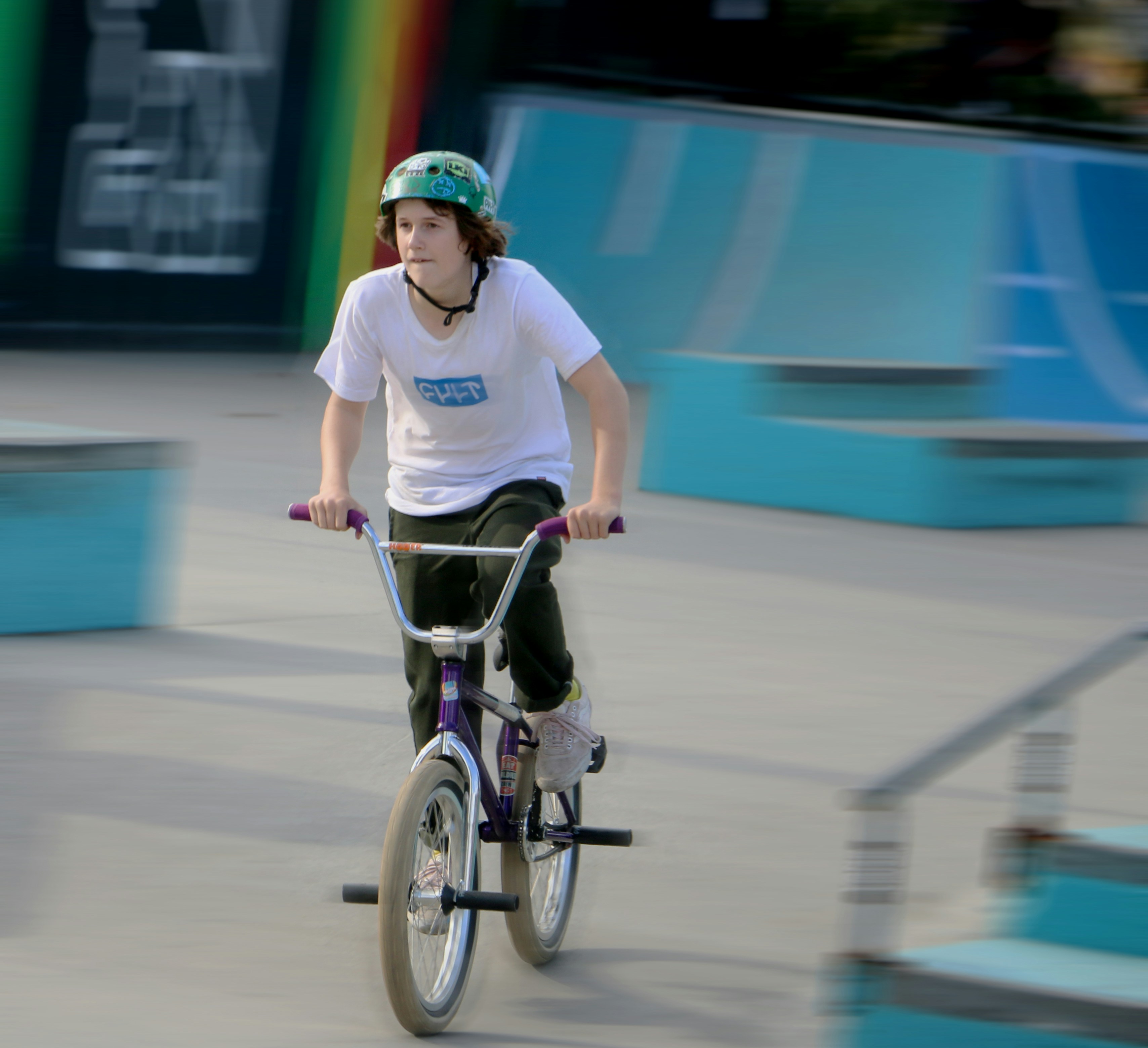shallow focus photo of boy in white crew-neck T-shirt riding BMX bike