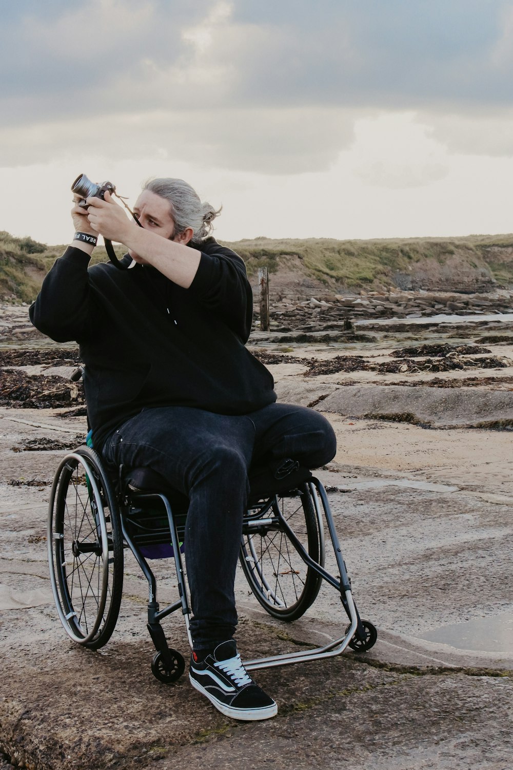 man taking photo while sitting on wheelchair