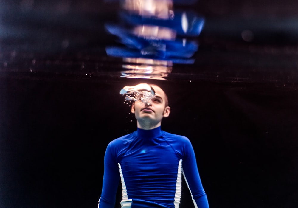 man wearing blue and white crew-neck long-sleeved shirt in body of water