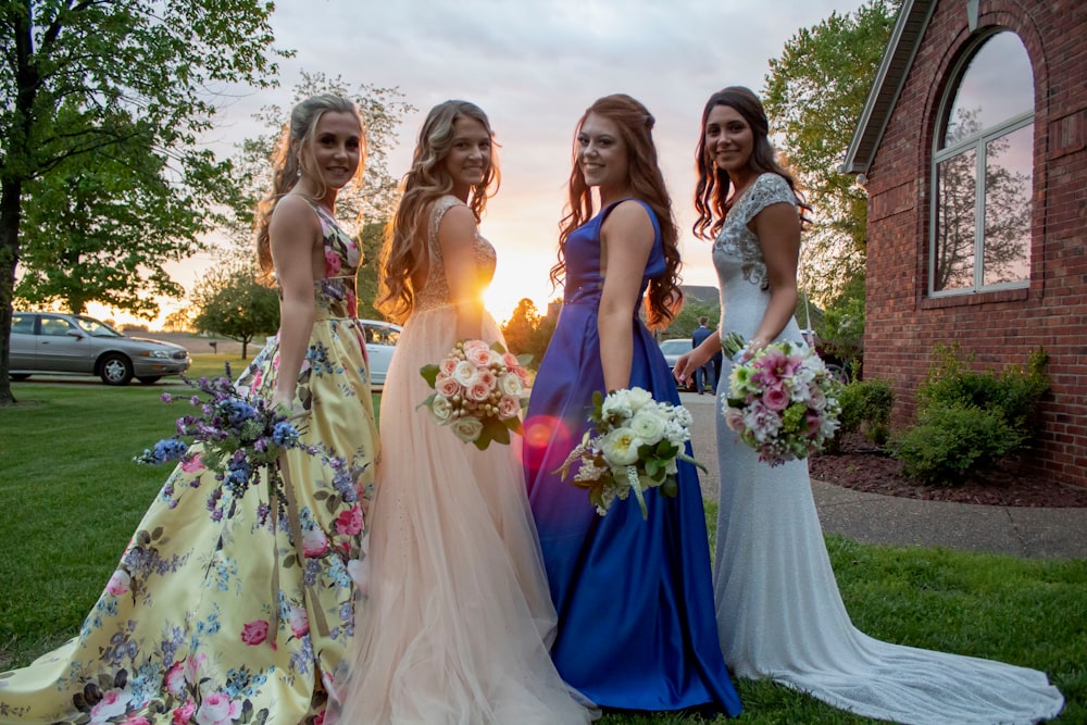 women in dress holding flower bouquets