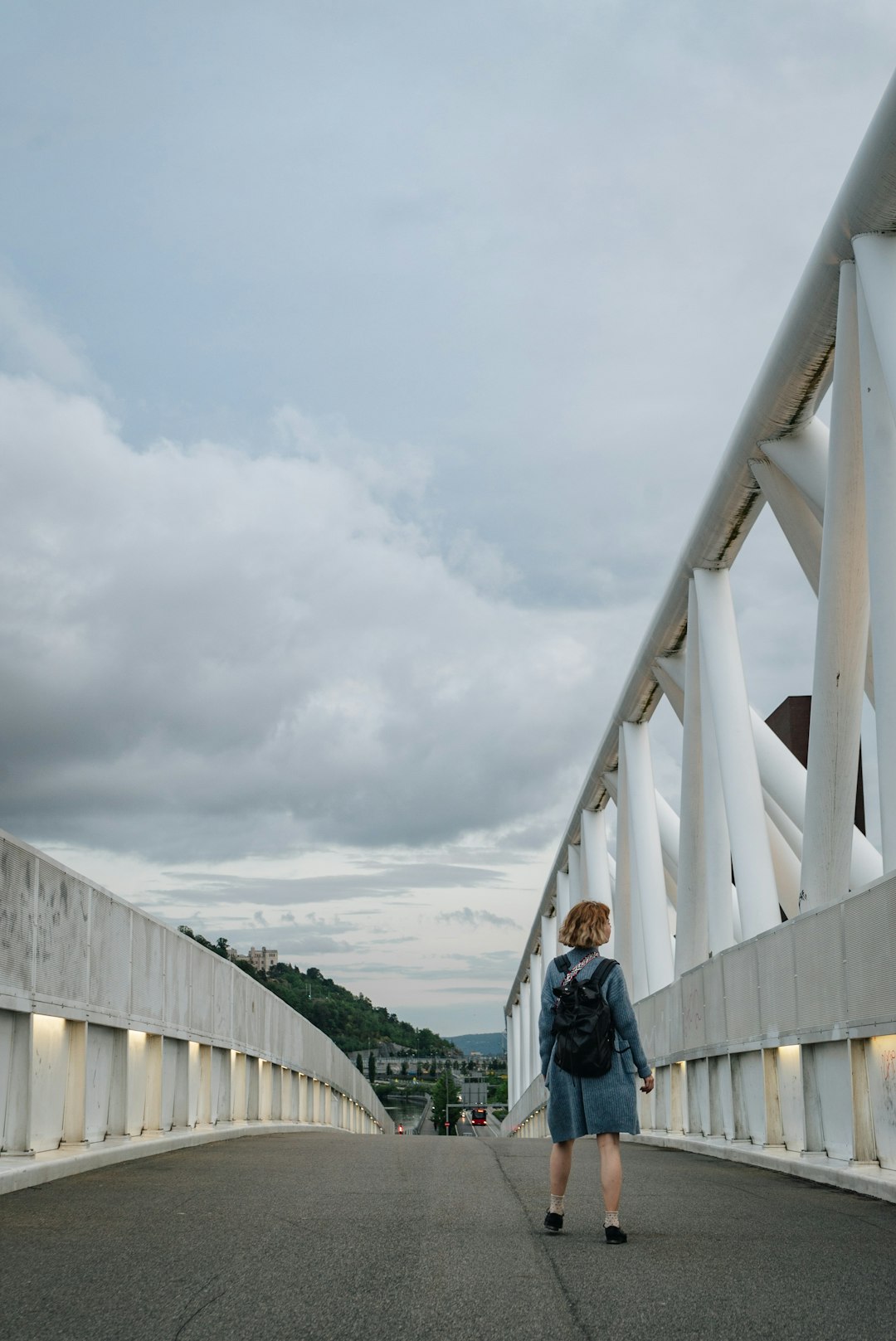 woman walking on concrete bridge