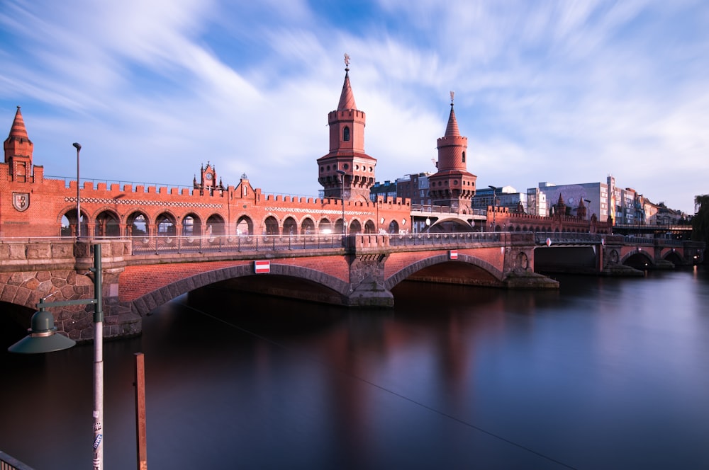 a bridge over a body of water with buildings in the background