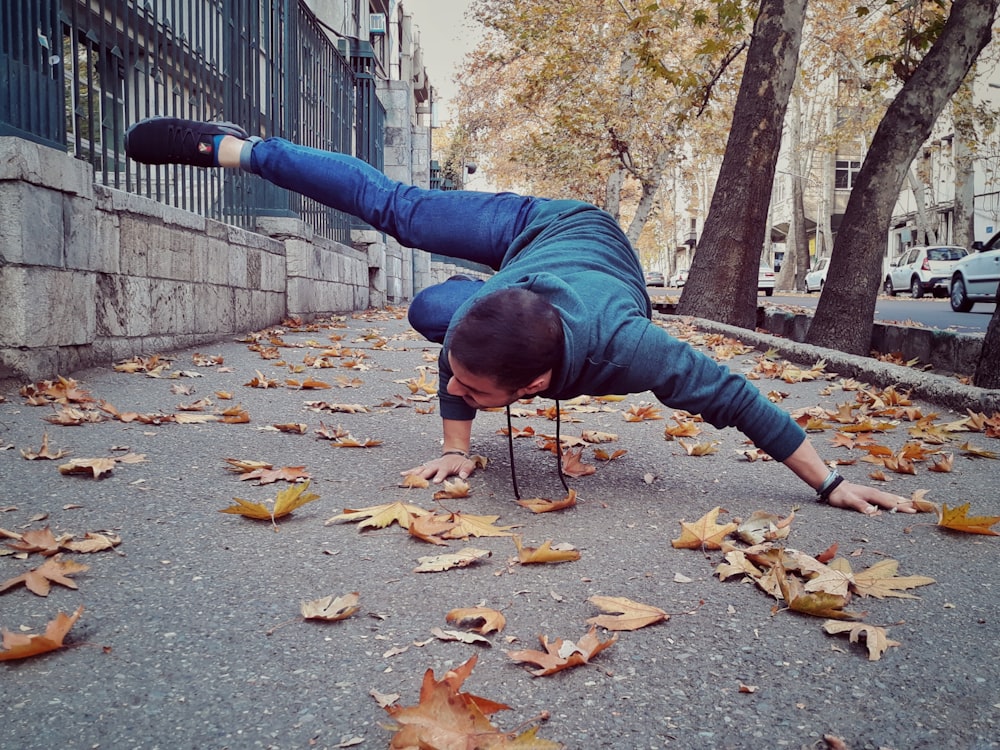 man doing hand stand beside street