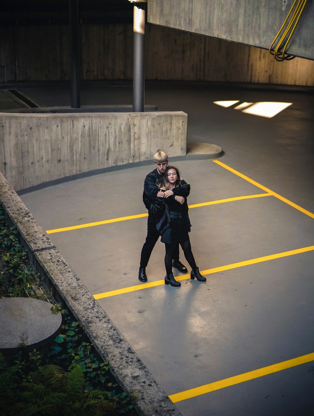 Mann im Begriff, Frau zu umarmen, die auf gelb-schwarzem Parkplatz steht
