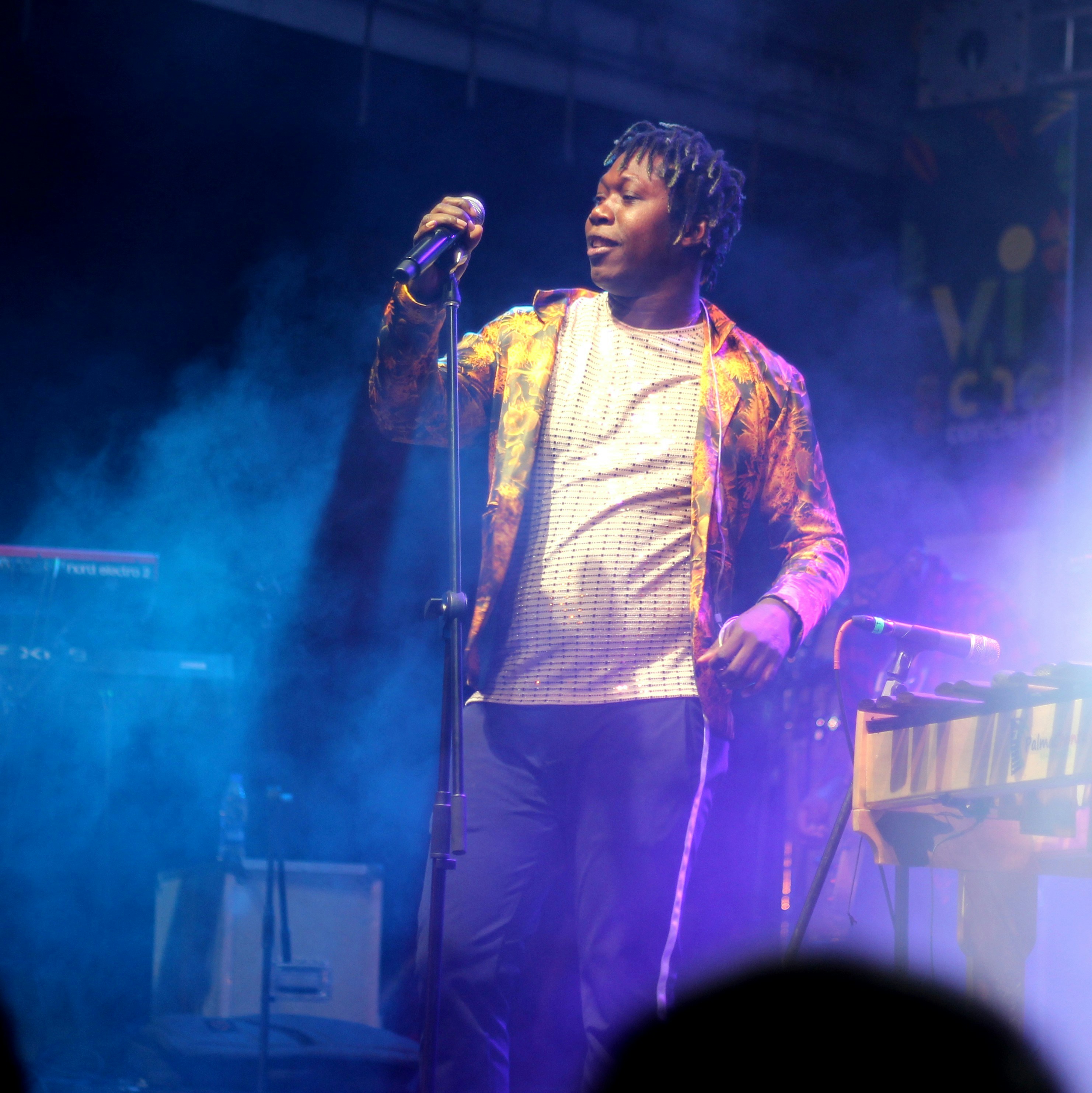 man in yellow and pink full-zip jacket holding wireless microphone