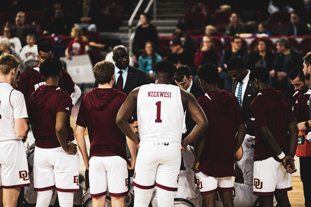 men playing basketball game surrounded with people watching them