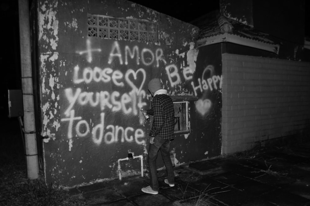 man using spray paint on wall