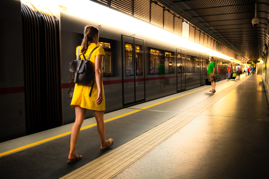 people walking at train station, Woman in yellow walking in a train station.