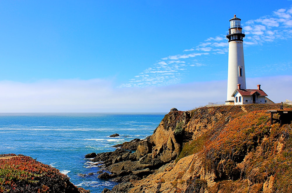 white lighthouse on cliff