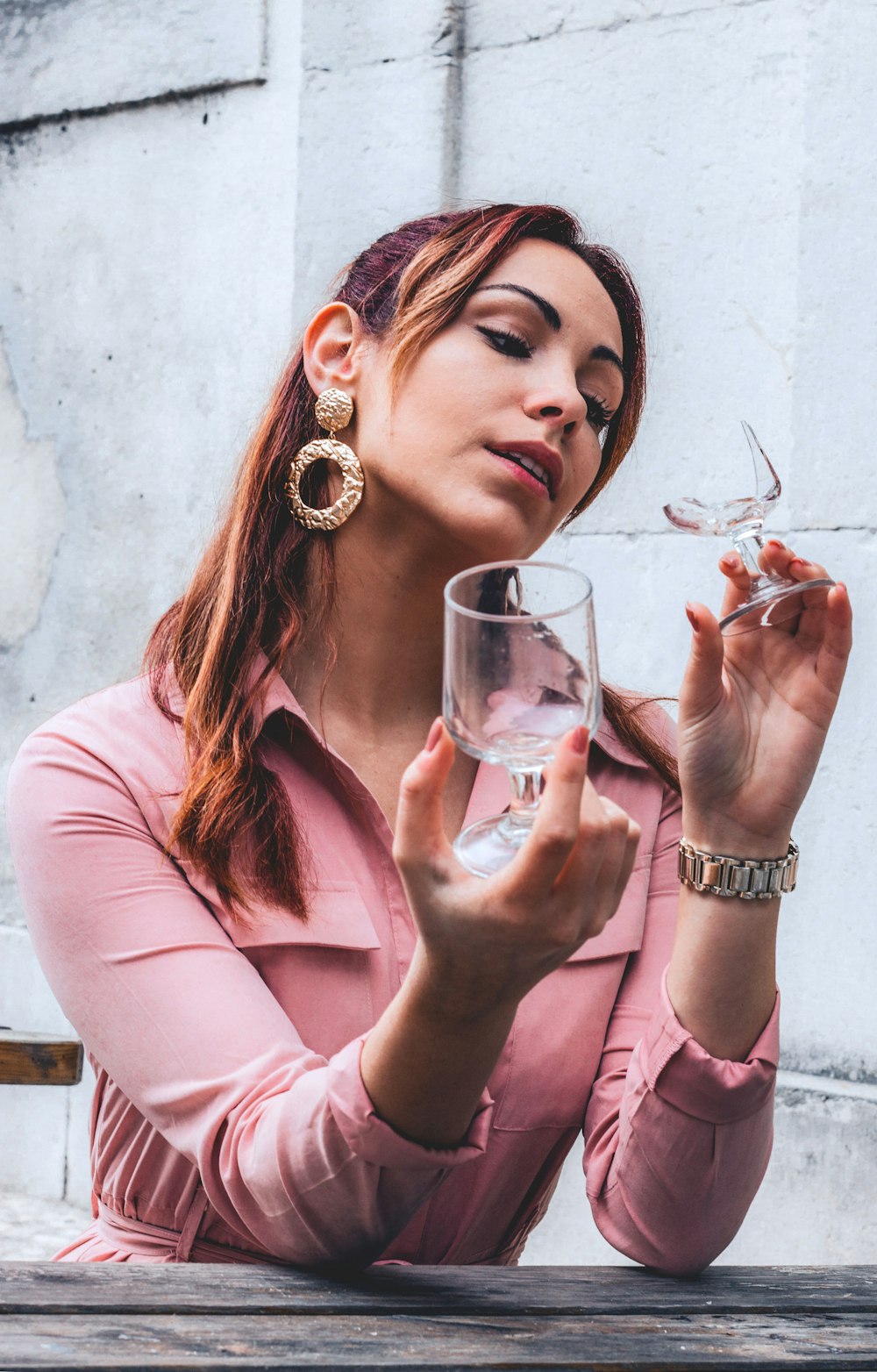 selective focus photography of sitting woman holding clear glass cups