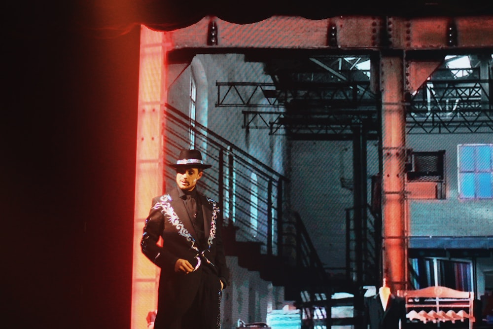 man wearing black suit with matching hat