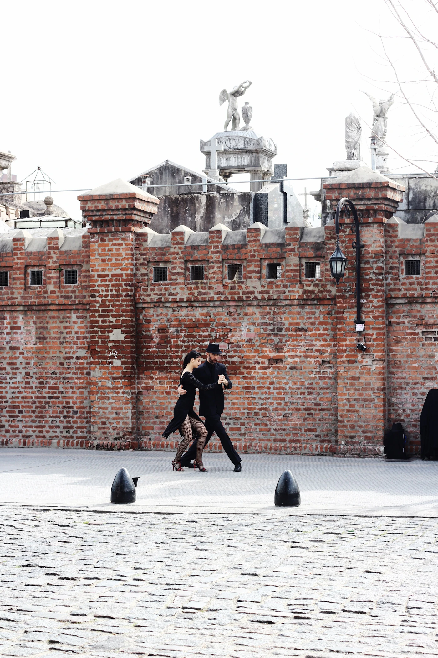 A couple dancing the tango in formal attire on the street in the Recoleta neighbourhood of Buenos Aires Argentina with the elegant Parisian-style architecture of the Buenos Aires neighbourhood behind them