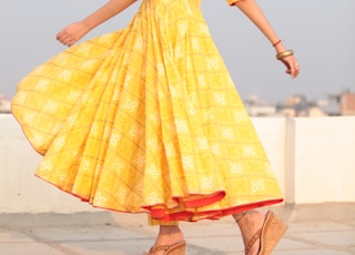 woman swishing her yellow long-sleeved maxi dress