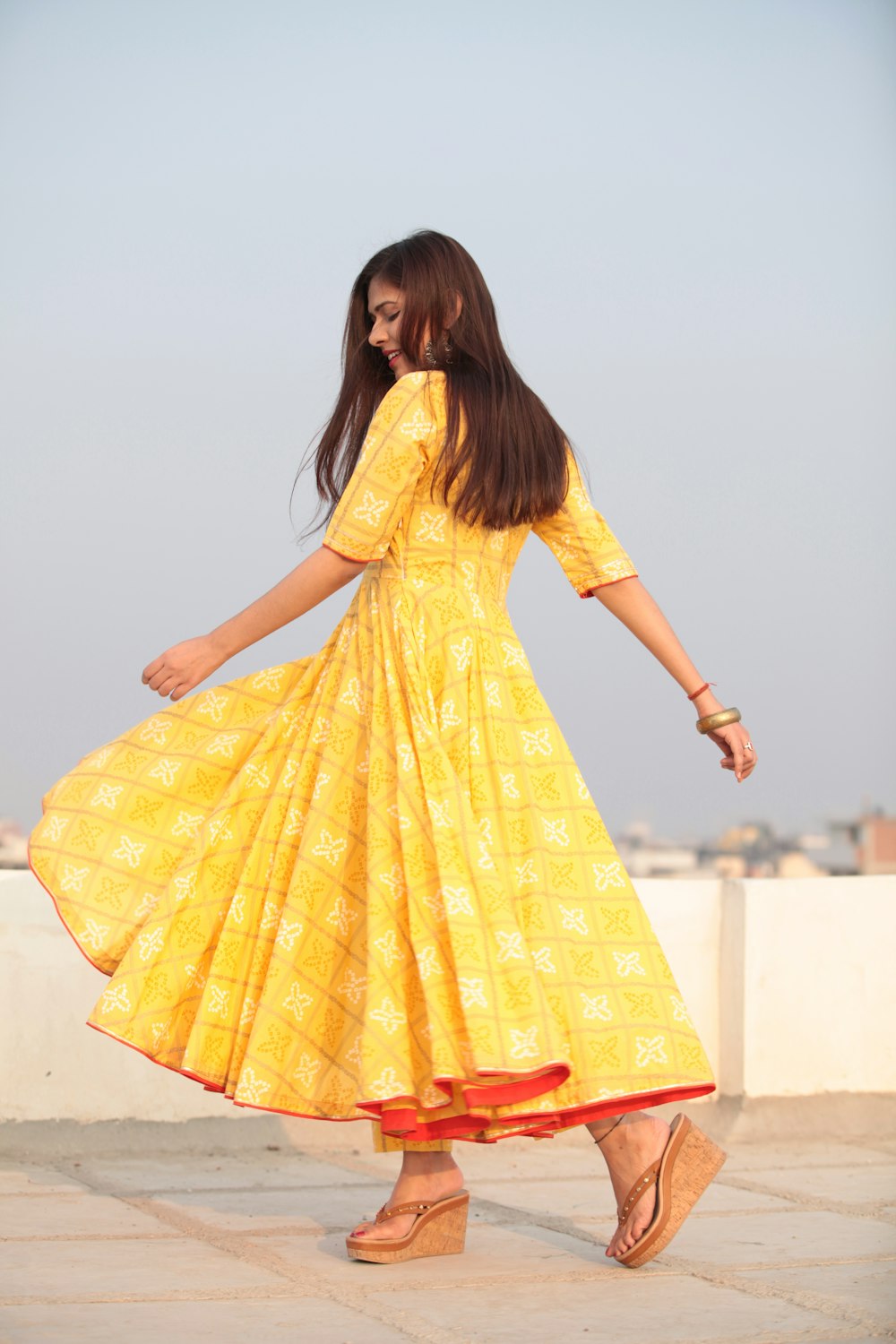 woman swishing her yellow long-sleeved maxi dress