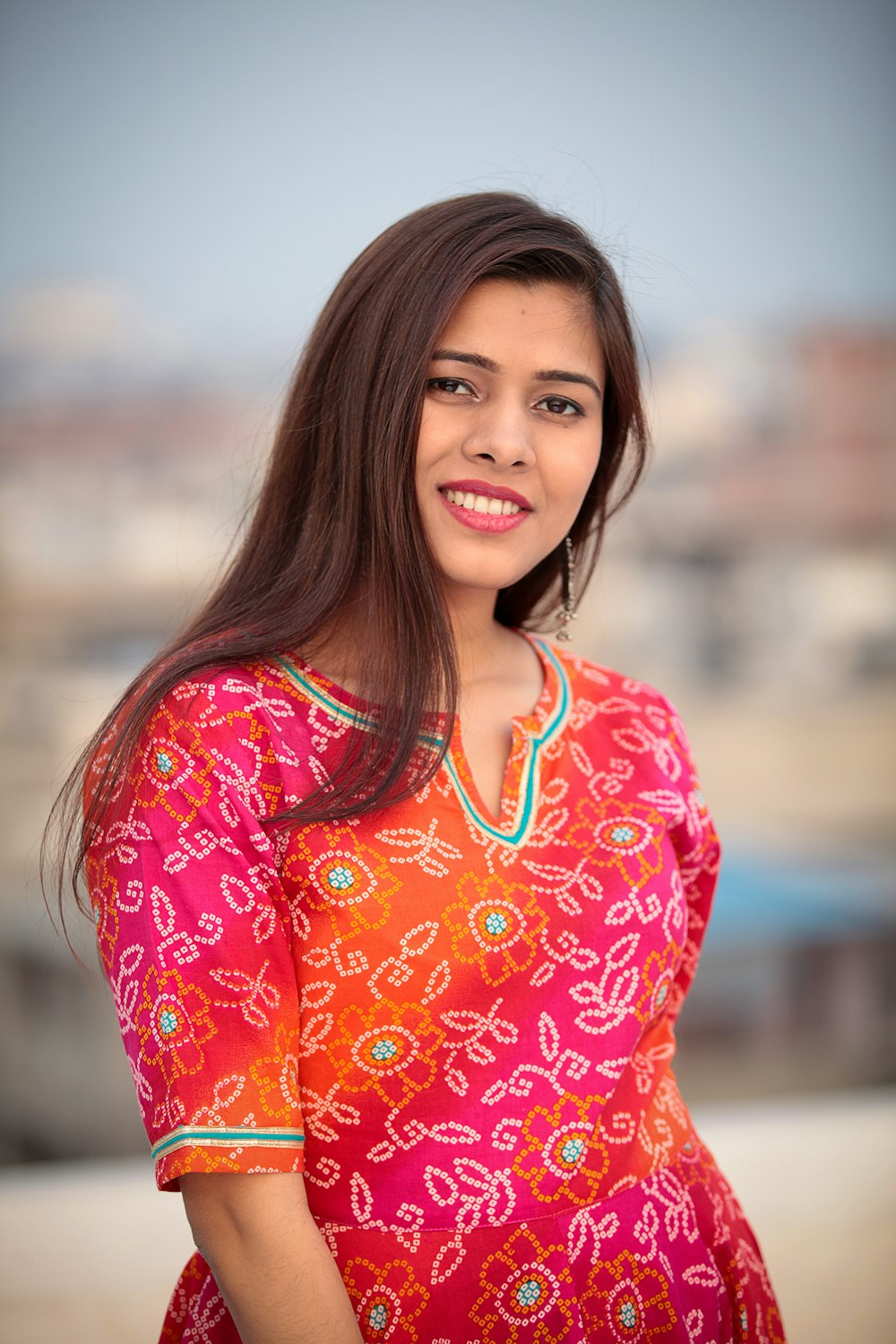 shallow focus photo of woman in pink and orange floral quarter-sleeved shirt