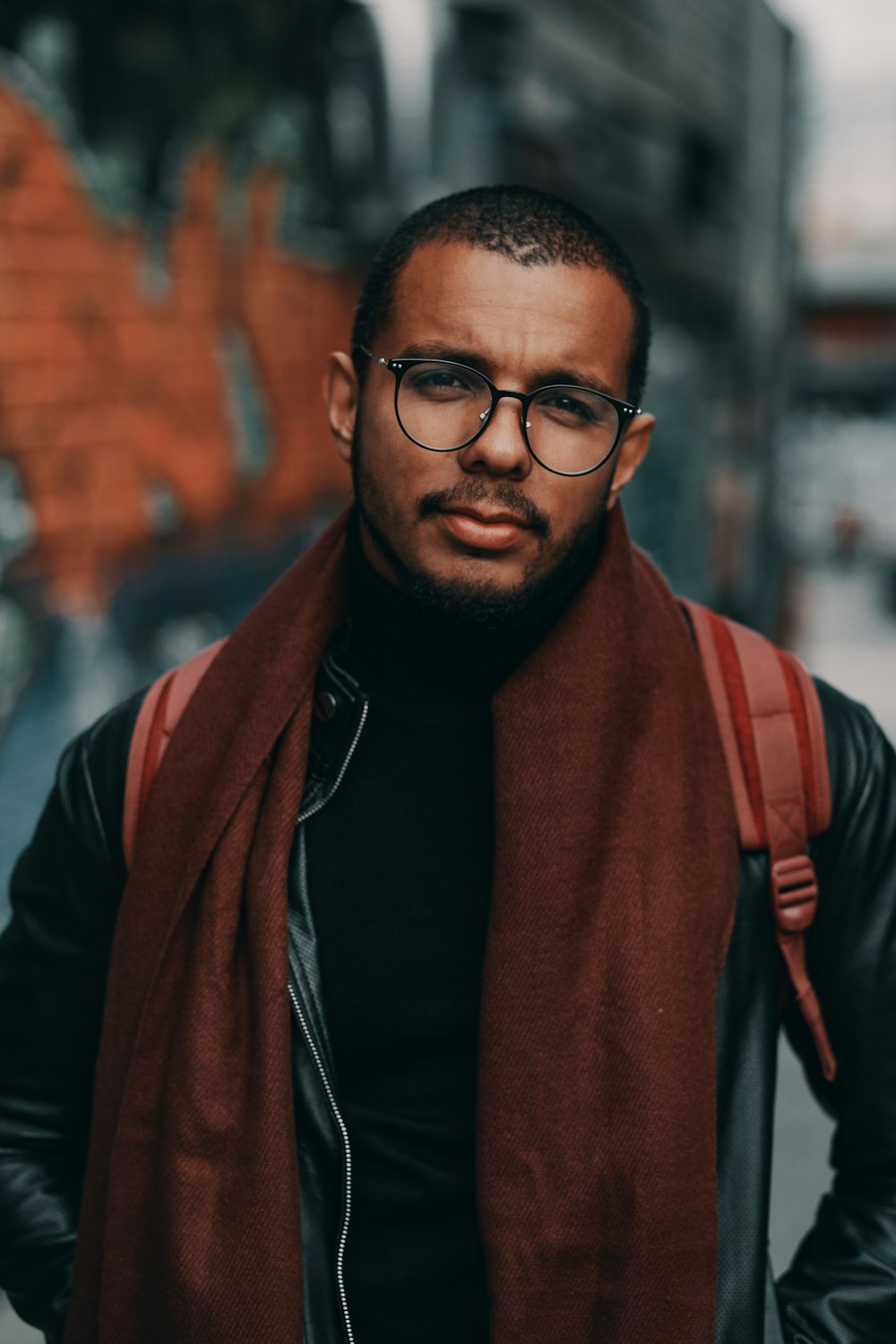 man wearing brown scarf and black jacket