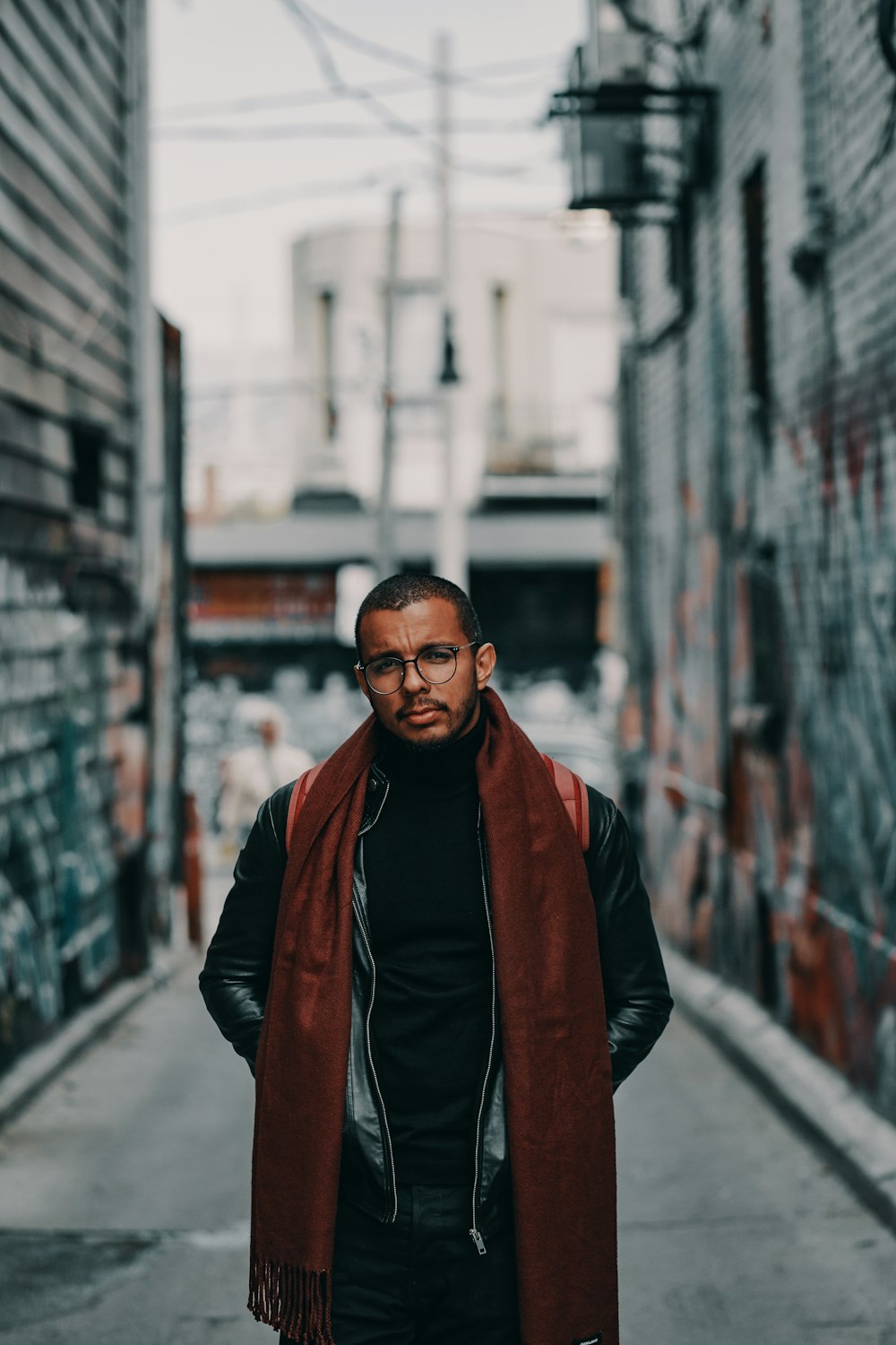 selective focus photo of man wearing brown scarf and black jacket