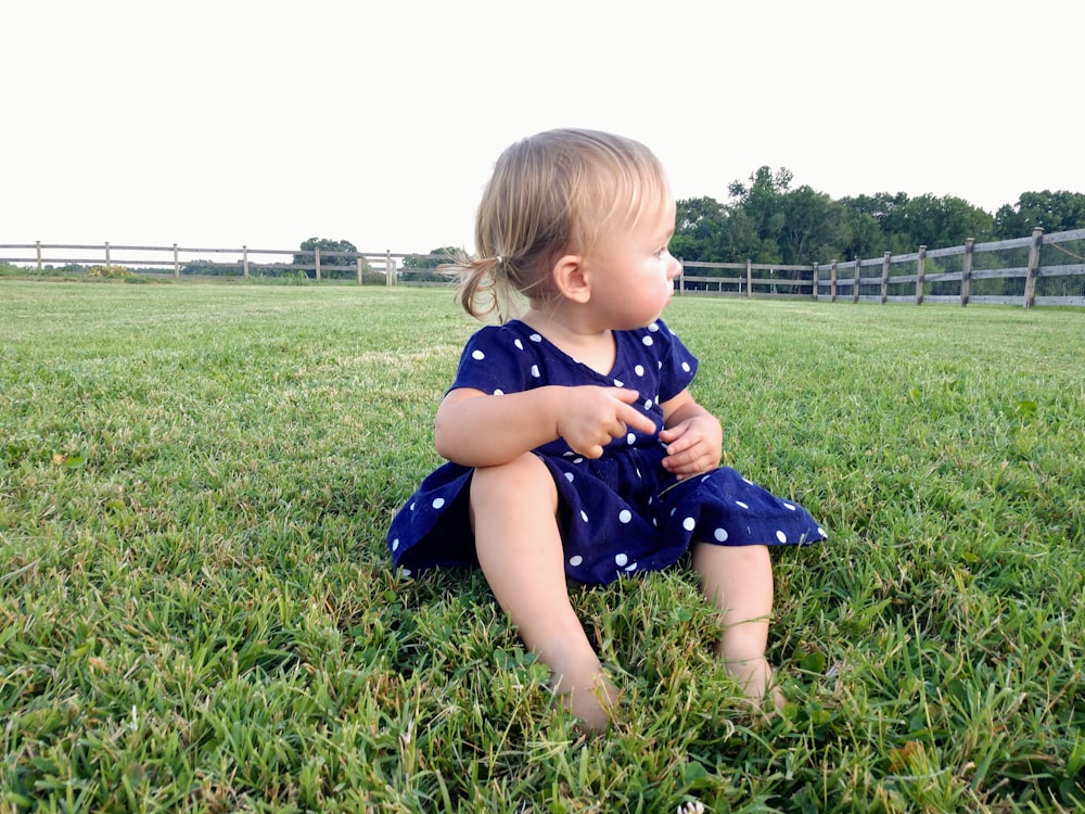 girl wearing purple dress sitting on ground