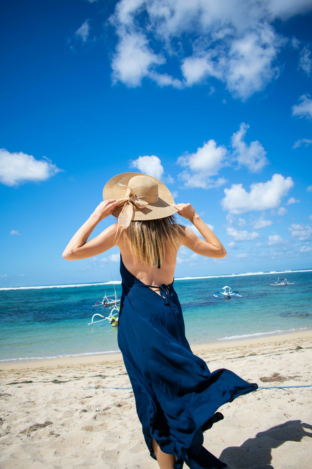 woman wearing blue open-back maxi dress