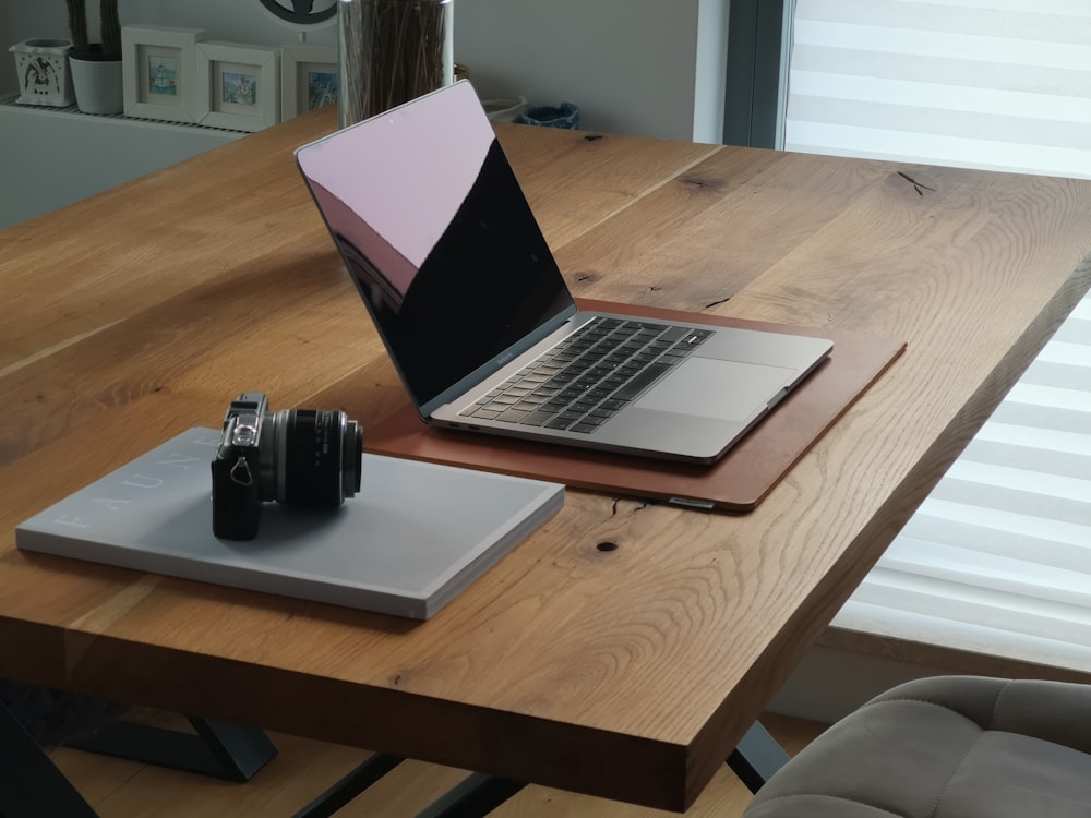 shallow focus photo of gray laptop computer on brown wooden table