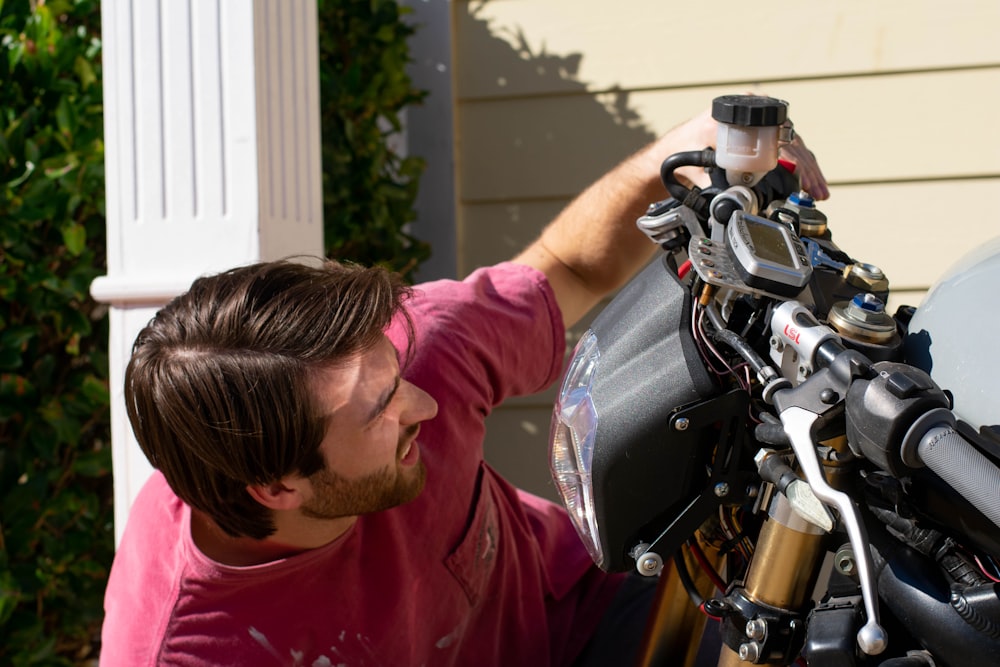 shallow focus photo of man looking at motorcycle headlight
