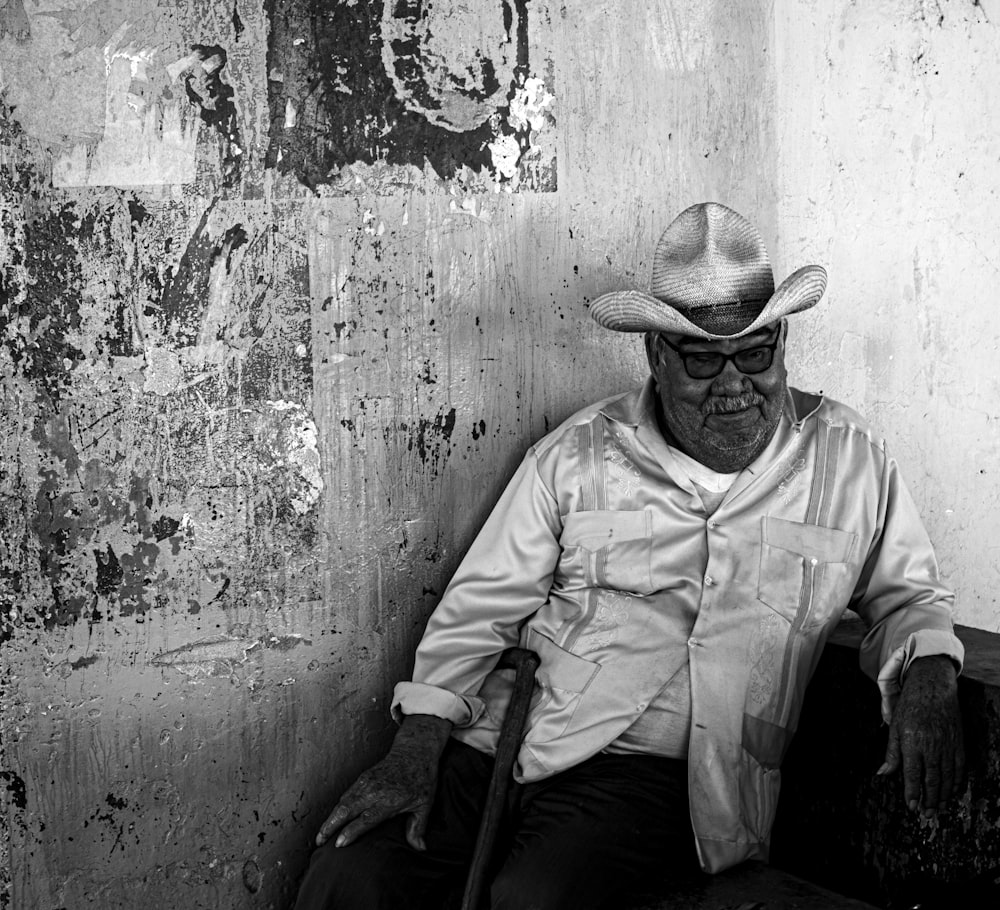 Mann mit Cowboyhut lehnt an Wand