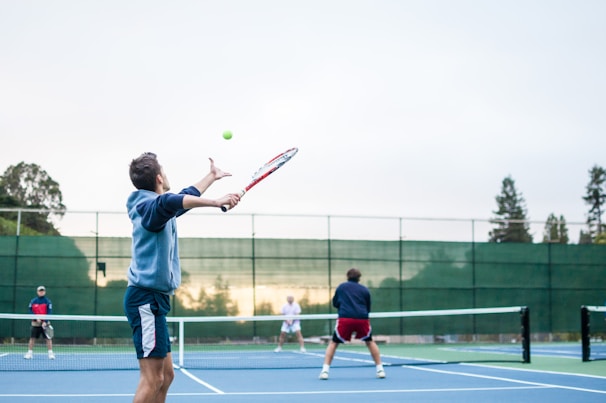Young tennis players practicing their serves on the court.