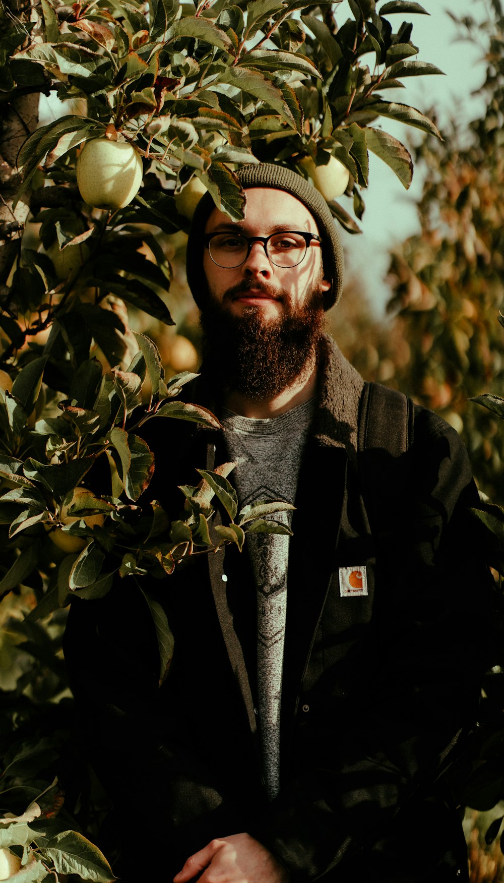 selective focus photography of man standing behind plants
