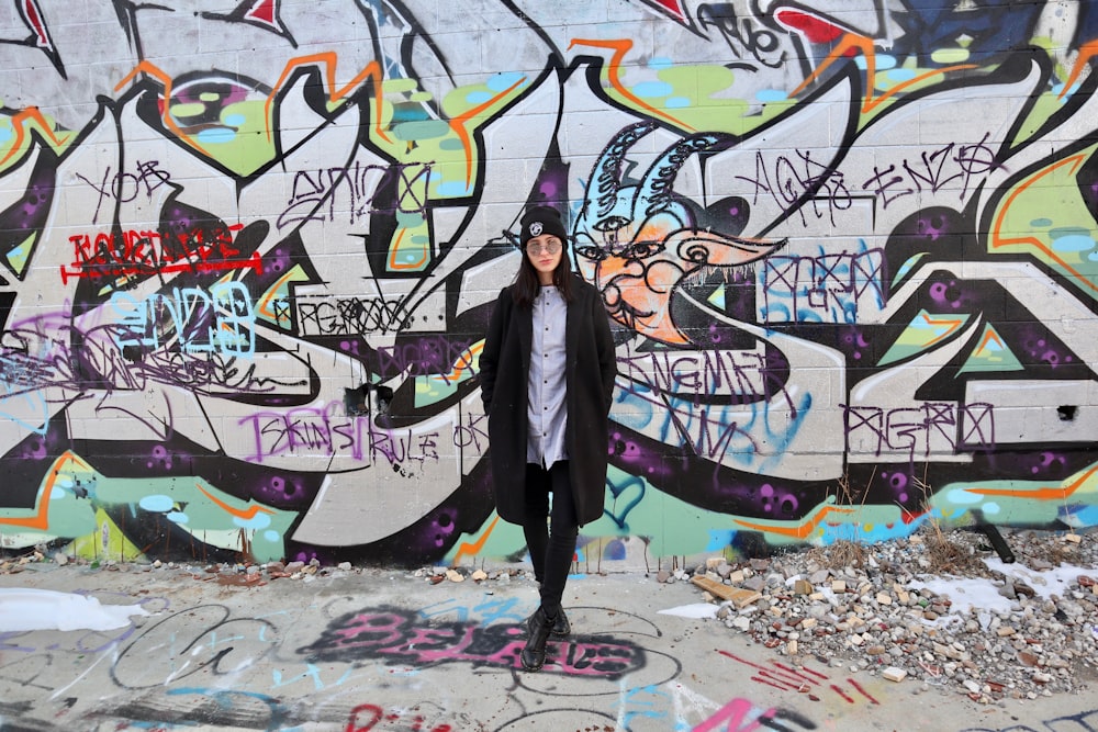 woman standing beside wall with mural