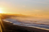 A misty Atlantic coastline at dawn with soft natural light illuminating the fog.