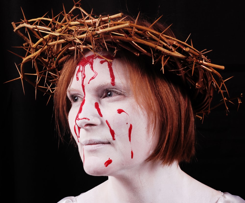 woman wearing brown thorn on head with red stain on her face
