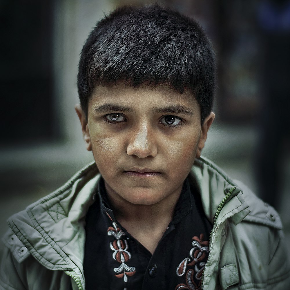 boy wearing green zip-up jacket