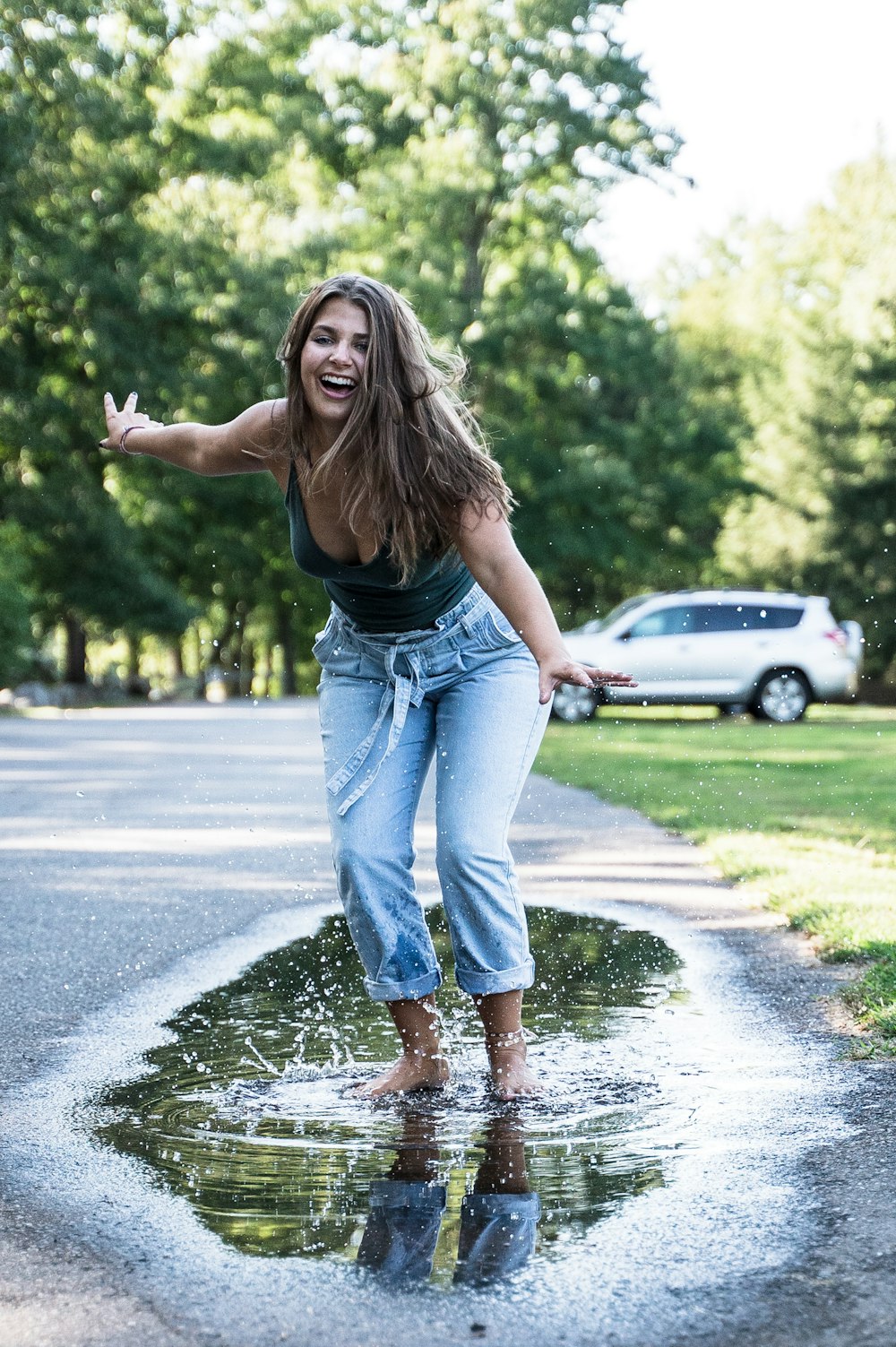 smiling woman wearing black top and blue denim jeans