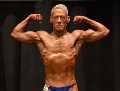 A competitor posing on stage after a successful competition prep.