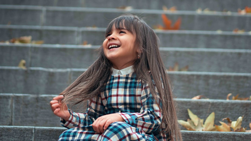 smiling girl sitting on stairs during daytime