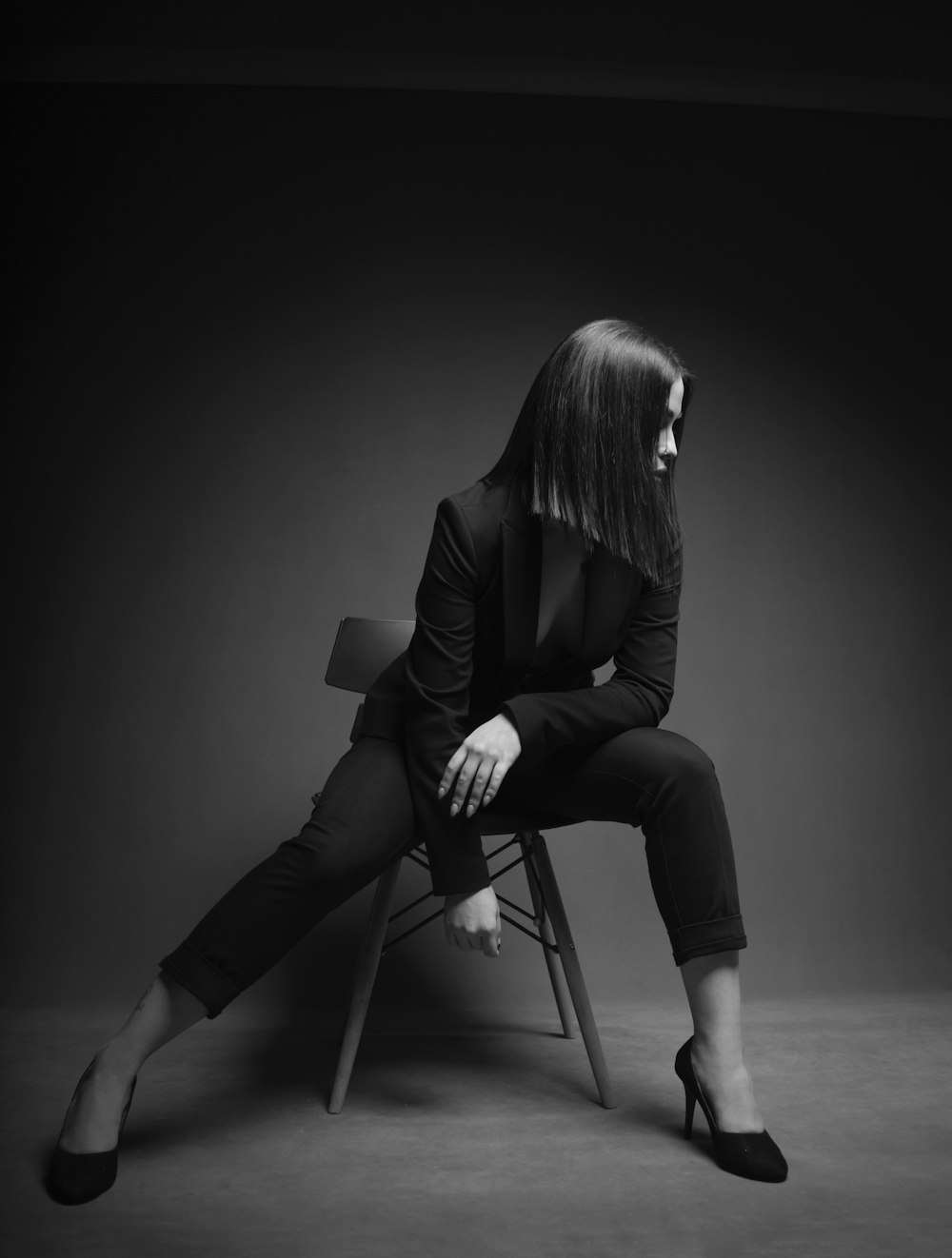 grayscale photography of woman sitting in a chair