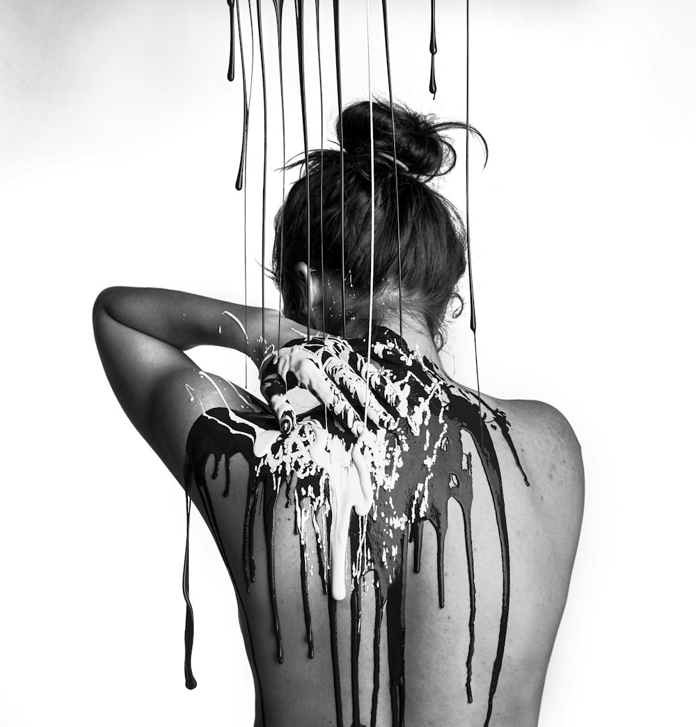 Photographie en niveaux de gris d’une femme en train de prendre une douche